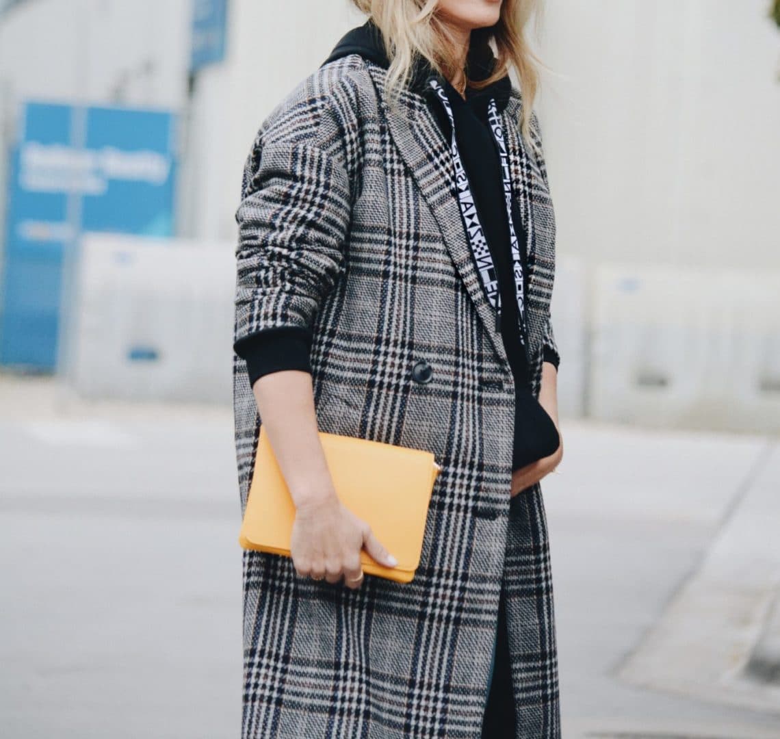 Proenza Hoodie styled with plaid jacket and yellow clutch - Her Fashioned Life